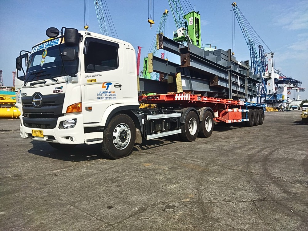 Truk LST Hino membawa balok baja di pelabuhan