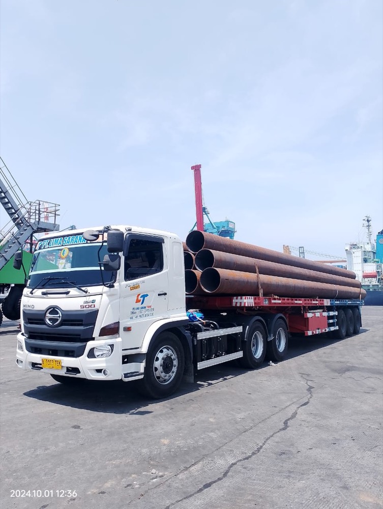Truk LST Hino bermuatan pipa baja